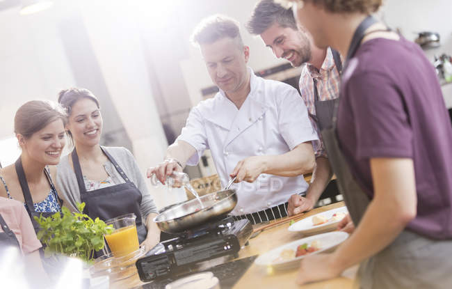 Students watching chef teacher in cooking class kitchen — Stock Photo