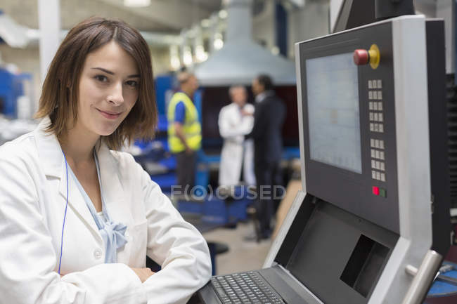 Portrait smiling female engineer at control panel in steel factory — Stock Photo