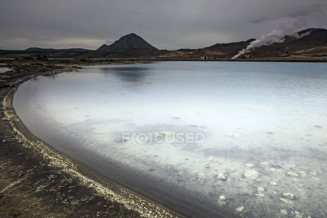 Frost pond water with hills on background — Stock Photo