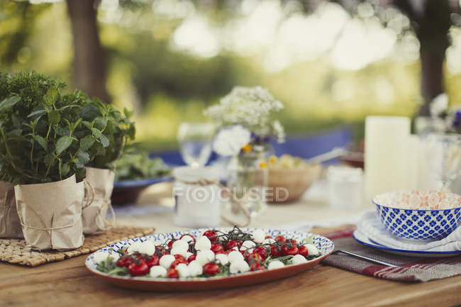 Caprese salad appetizer on patio table — Stock Photo