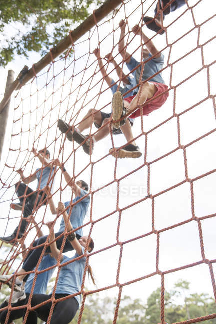 Люди піднімаються по сітках на перешкодній трасі табору — стокове фото