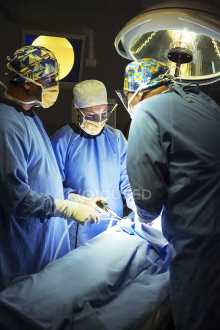 Cirujanos realizando cirugía en quirófano - foto de stock