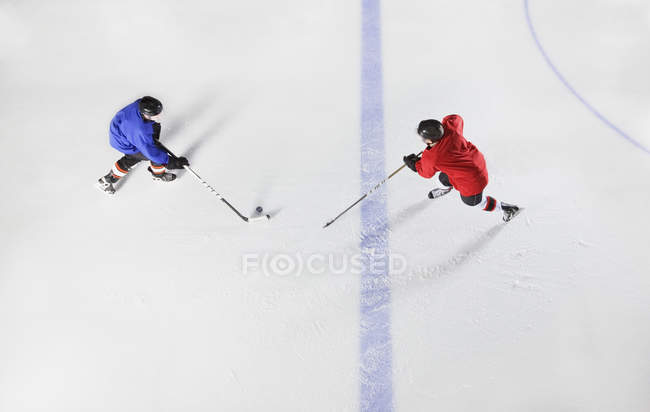 Overhead view hockey players going for puck on ice — Stock Photo
