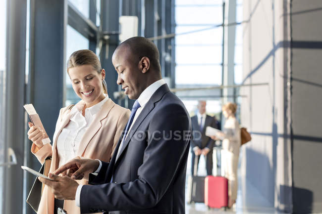 Деловые люди, использующие цифровой планшет в аэропорту — стоковое фото