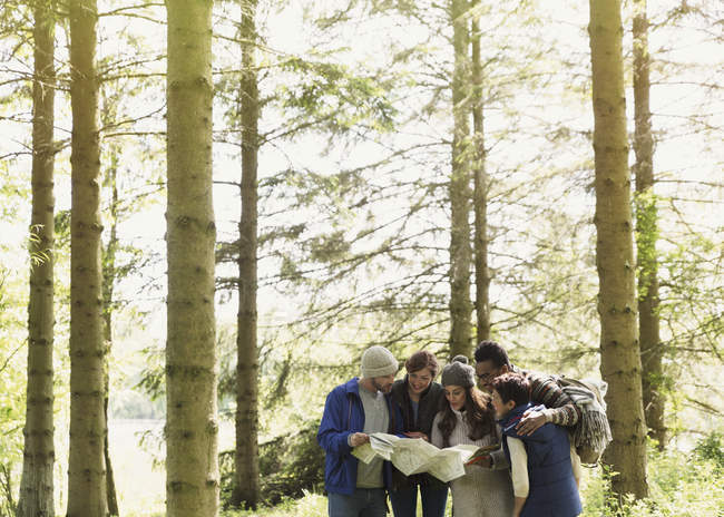 Freunde mit Karte wandern im Wald — Stockfoto