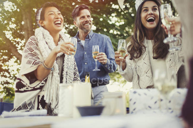 Друзья смеются и пьют шампанское на дне рождения — стоковое фото