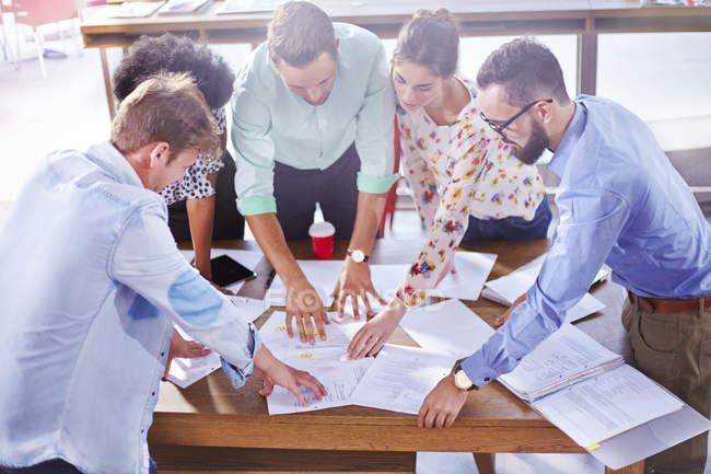 Empresários analisando papelada e brainstorming em reunião — Fotografia de Stock