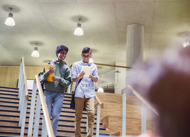 Estudantes universitários com caderno descendo escadas — Fotografia de Stock