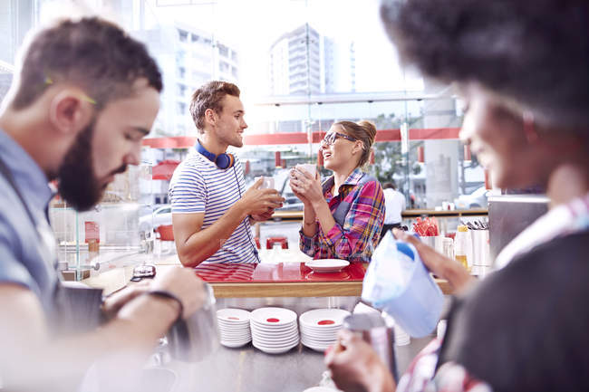 Couple talking and drinking coffee in cafe — Stock Photo