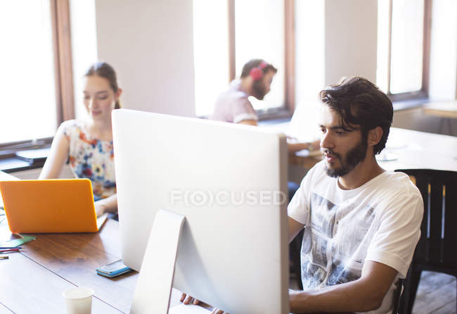 Casual businessman working at computer in office — Stock Photo
