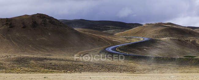 Estrada sinuosa rodeada por colinas durante o dia — Fotografia de Stock
