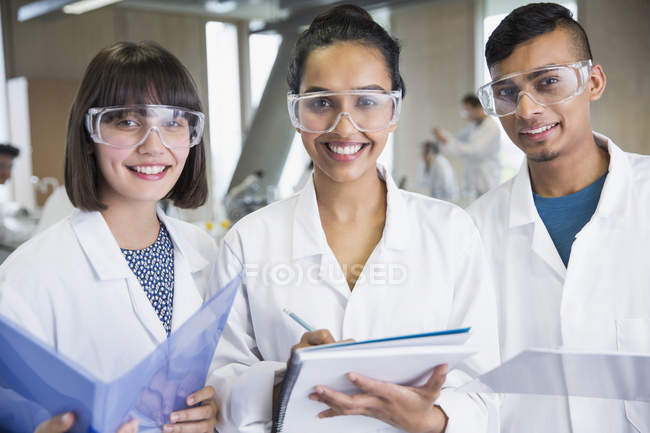 Portrait étudiants souriants du collège en blouse de laboratoire de sciences — Photo de stock