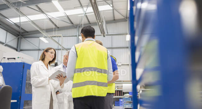 Engineers and worker talking in steel factory — Stock Photo