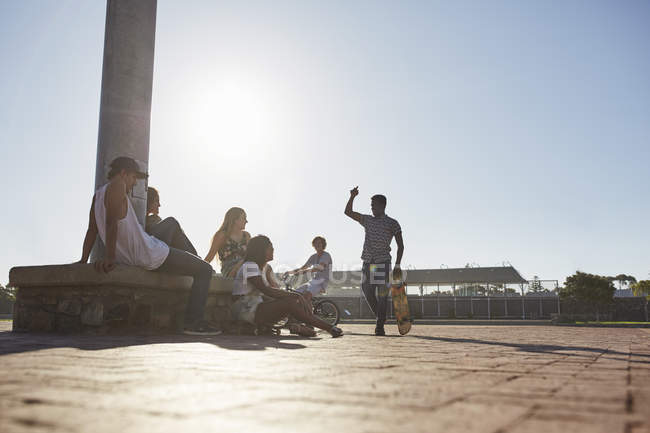 Подростковые друзья тусуются в солнечном скейтпарке — стоковое фото