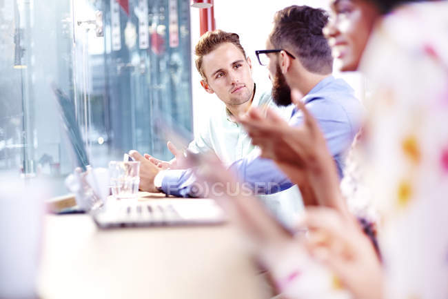 Jeunes hommes d'affaires se réunissant dans un café moderne — Photo de stock