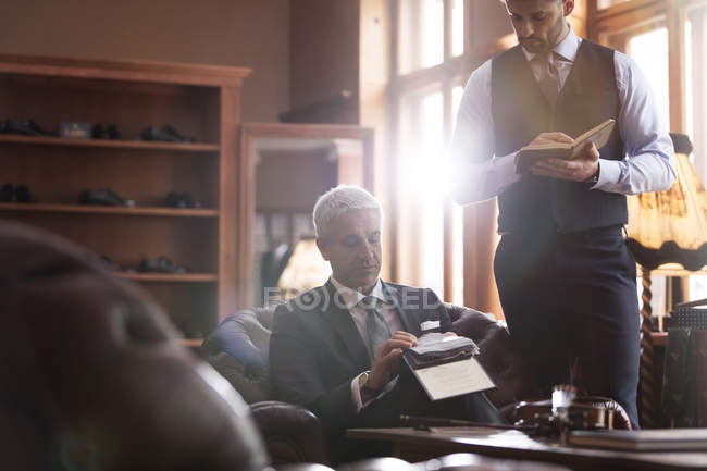 Портной и бизнесмен просматривает ткани в магазине мужской одежды — стоковое фото