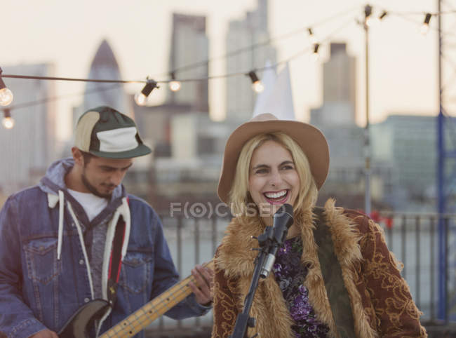 Musiker spielen Gitarre und singen bei Dachparty — Stockfoto