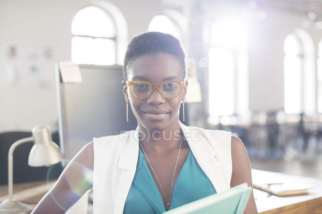 Retrato mujer de negocios confiada con gafas en la oficina - foto de stock