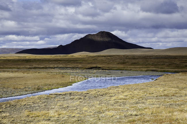 Маленький ставок на полі і пагорби на фоні — стокове фото