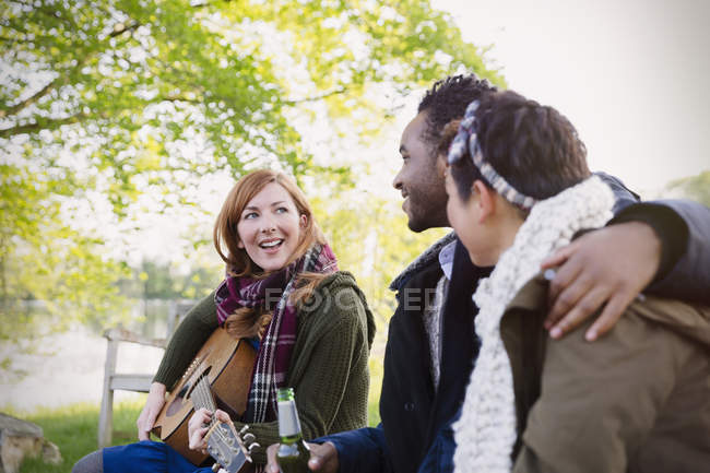 Friends playing guitar and drinking beer — Stock Photo