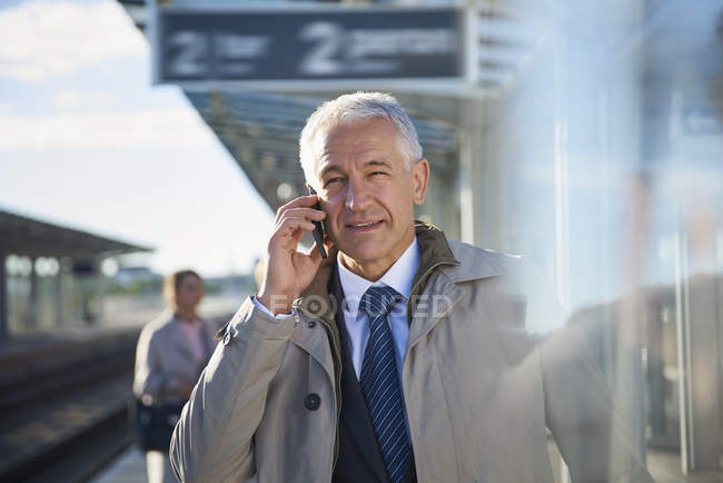 Бизнесмен разговаривает по мобильному телефону возле аэропорта — стоковое фото