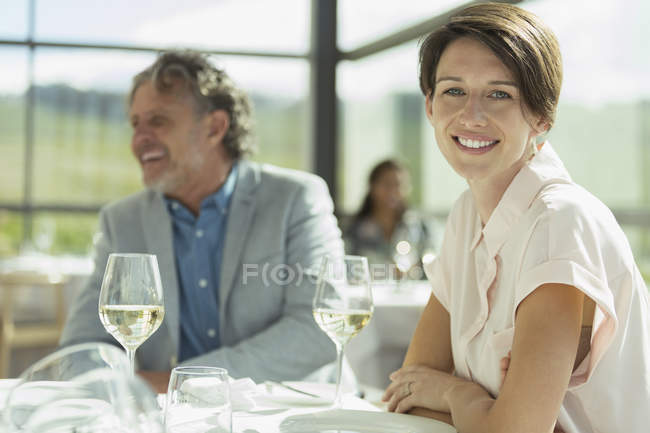 Портрет усміхненої жінки, що п'є вино в сонячному ресторані — стокове фото