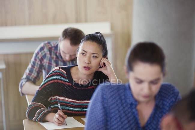 Pensive female college student taking test in classroom — Stock Photo