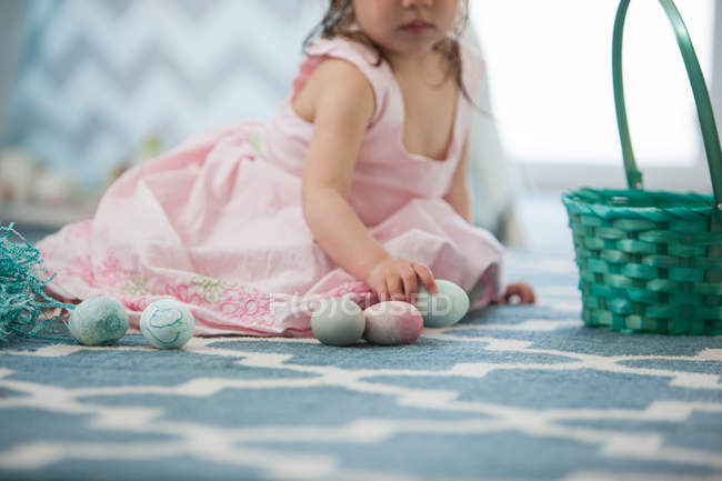 Девушка в розовом платье с пасхальными яйцами — стоковое фото