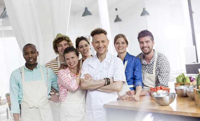 Portrait souriant professeur de chef et les étudiants en cuisine de classe de cuisine — Photo de stock