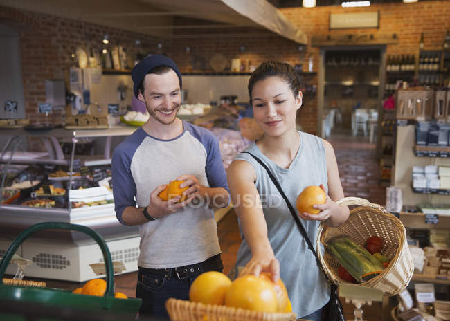 Pareja de compras de naranjas en el mercado - foto de stock