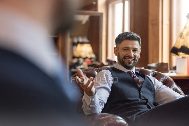 Усміхнений бізнесмен жестикулює в магазині чоловічого одягу — стокове фото
