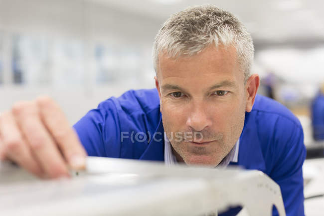 Primer plano del trabajador examinando pieza en fábrica de acero - foto de stock