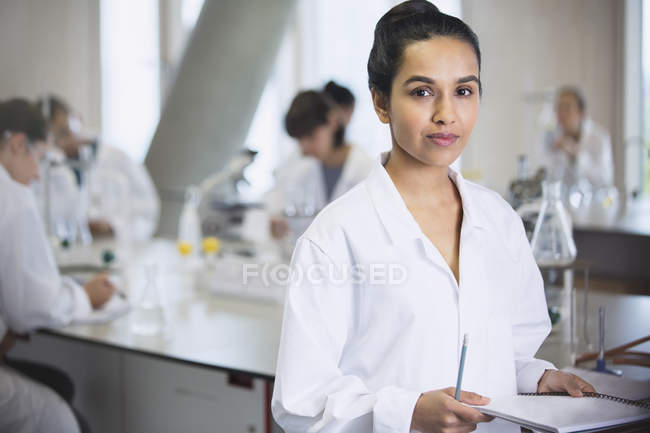 Retrato sério estudante universitário feminino em sala de aula de laboratório de ciências — Fotografia de Stock
