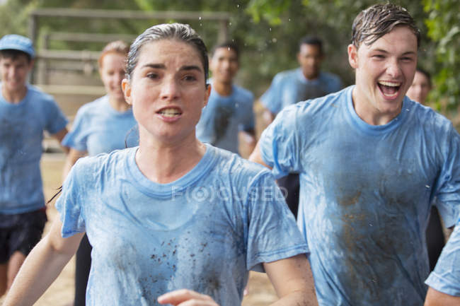 Donna determinata che corre sul percorso ad ostacoli del campo di addestramento — Foto stock