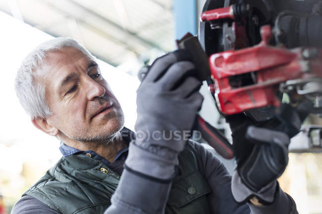 Close up focado mecânico substituindo pastilhas de freio na oficina de reparação de automóveis — Fotografia de Stock