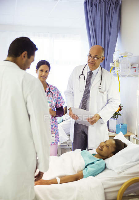 Ärzte und Krankenschwester drehen ihre Runden im Krankenhauszimmer — Stockfoto