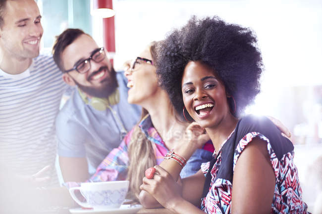 Retrato de la mujer riendo pasando el rato con amigos en la cafetería - foto de stock
