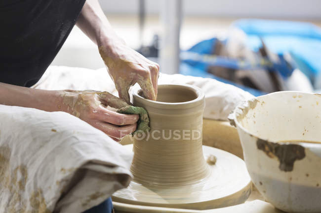 Femme utilisant la roue de poterie en studio — Photo de stock