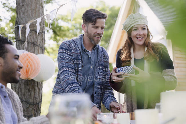 Friends serving food at patio lunch — Stock Photo