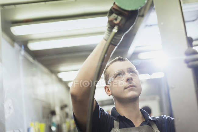 Працівник шліфує сталь на металургійному заводі — стокове фото