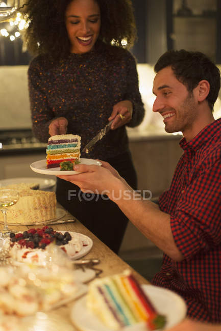Woman serving layer cake to man at table — Stock Photo