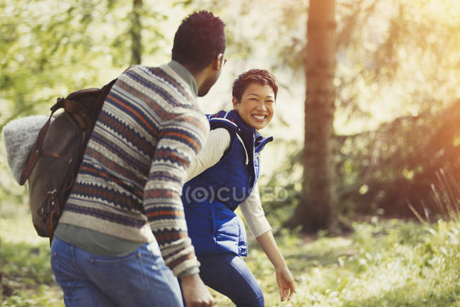 Laughing couple hiking with backpack in woods — Stock Photo