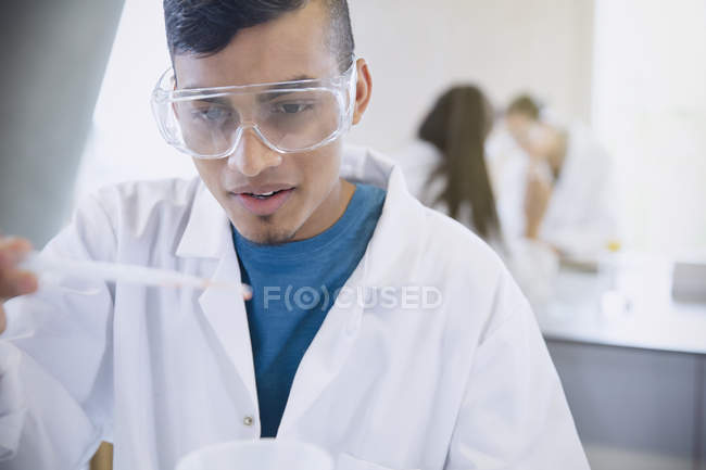 Estudiante universitario masculino realizando experimento científico en aula de laboratorio de ciencias — Stock Photo