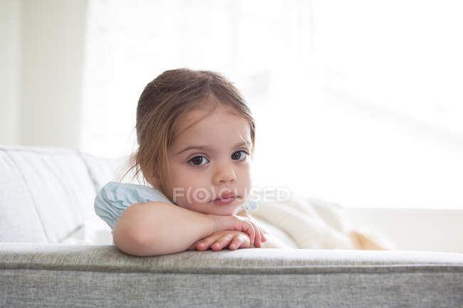 Portrait of serious girl on sofa — Stock Photo