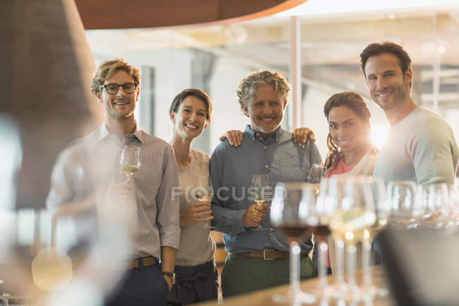 Retrato amigos sonrientes degustación de vinos en la bodega - foto de stock