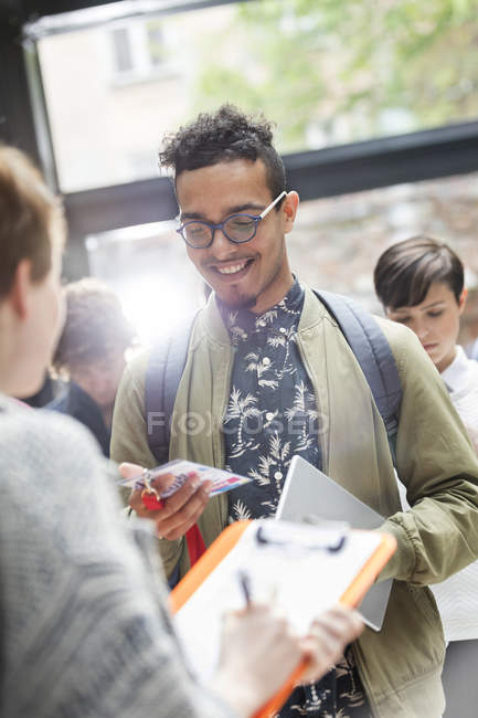 Lächelnder junger Mann zeigt Referenzen auf Technologiekonferenz — Stockfoto