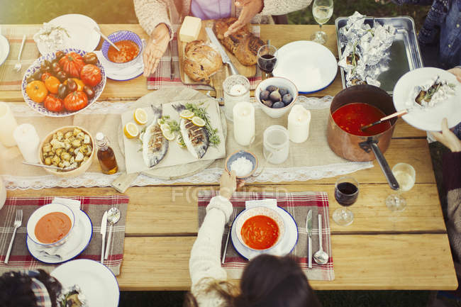 Amigos disfrutando del almuerzo en la mesa del patio - foto de stock