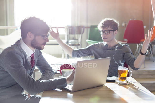 Empresários casuais usando laptop no café — Fotografia de Stock