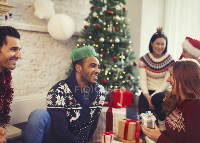 Amigos abrindo presentes de Natal na sala de estar — Fotografia de Stock