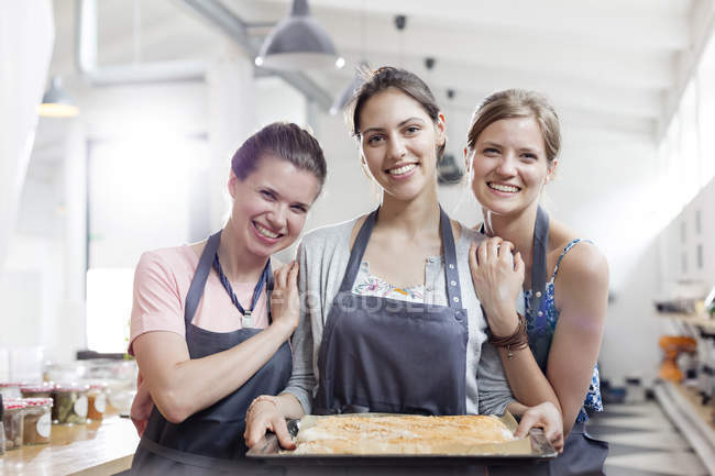 Портрет усміхнених друзів, які насолоджуються класом приготування їжі на кухні — стокове фото